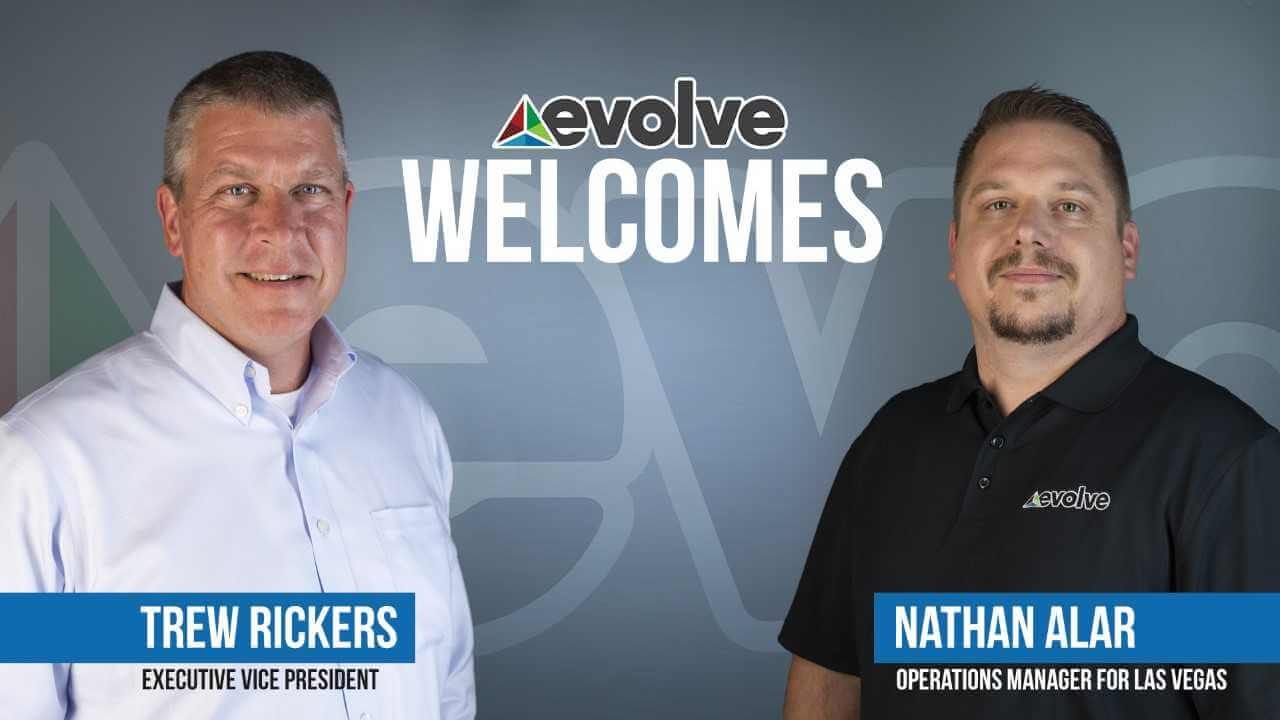 Two men standing next to each other with the words evolve welcome.