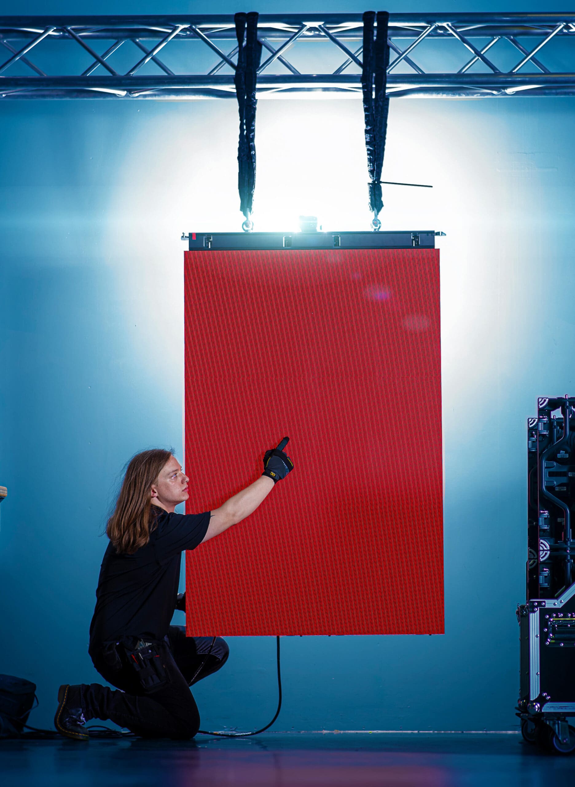 A woman is holding a large red sheet of paper.